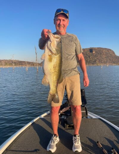 Angler with largemouth bass caught on a Bass Boats 4 Sale day trip