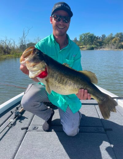 Angler with largemouth bass caught on a Bass Boats 4 Sale day trip